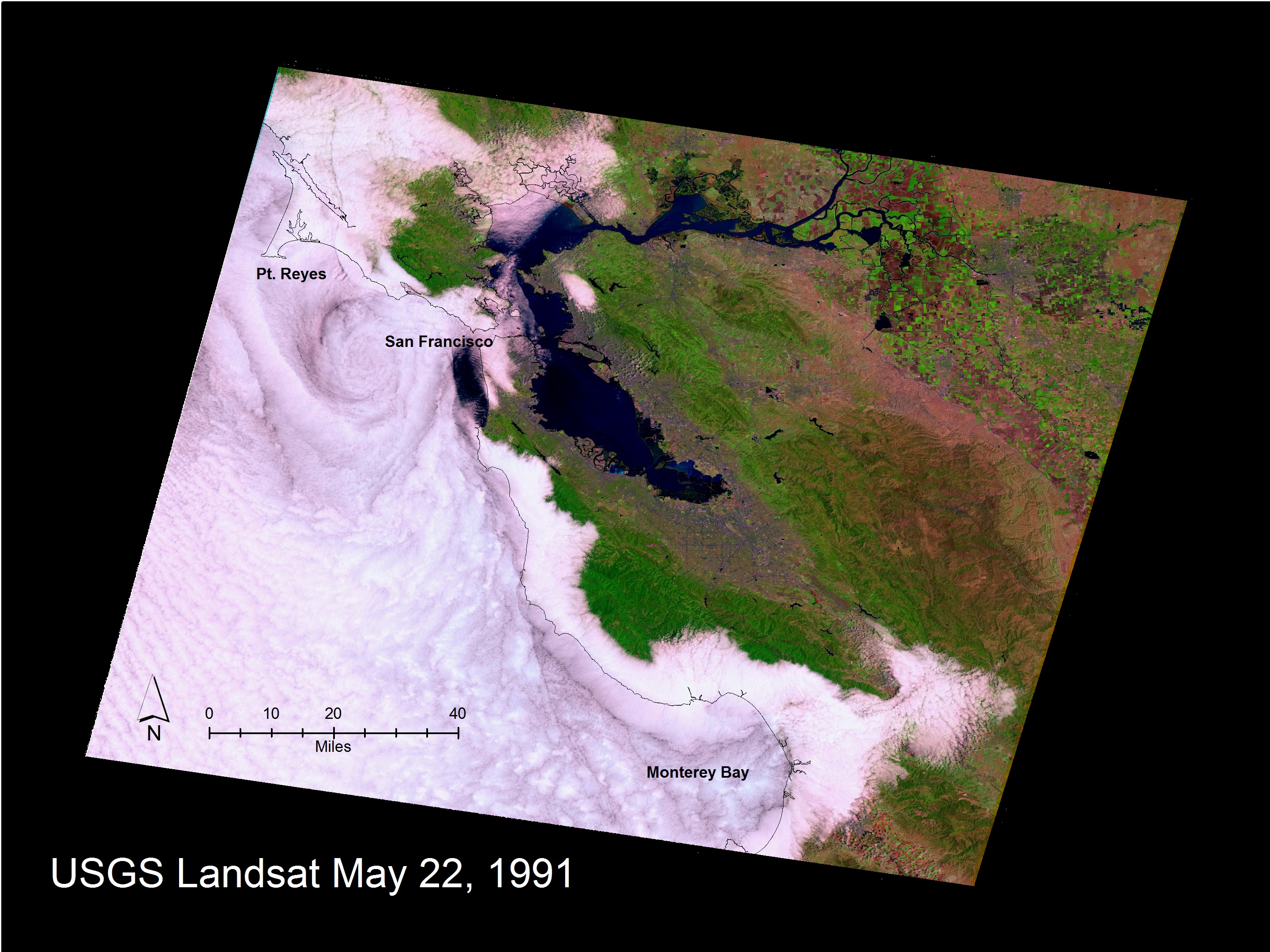A Landsat image from May 22, 1991, shows the relative position of the coastline, mapped as a black line on top of the marine stratus and stratocumulus cloud layer along the San Francisco to Monterey, California, coastline. The effect of coastal mountains that form a topographic barrier keeping the marine layer offshore is visible, as are the gaps north of Point Reyes and to the east of Monterey Bay through which the clouds penetrate. A complex eddy pattern can be seen offshore of San Francisco in the lee of the Point Reyes peninsula that juts out to sea.