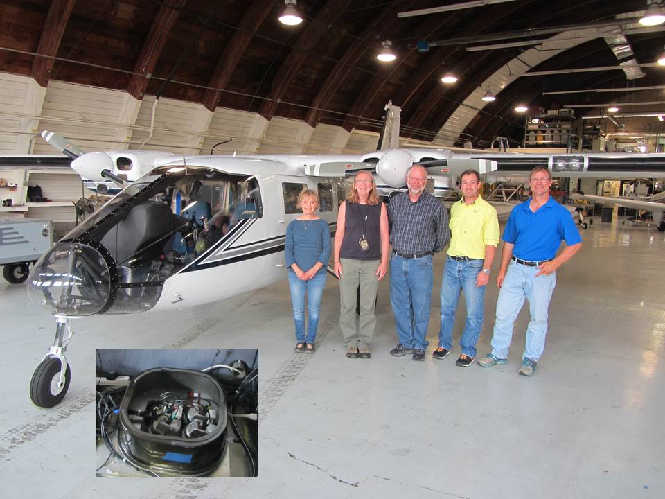 HiDef Aerial Camera system (inset image) with evaluation team, (l-r) Mary Mitchell, Mary Balogh, Larry Robinson (USGS), Jim Wortham, and Brian Lubinski standing in front of the Midwest Region's Partenavia Observer aircraft in a hangar at Fleming Field, Minnesota, on June 29, 2015.