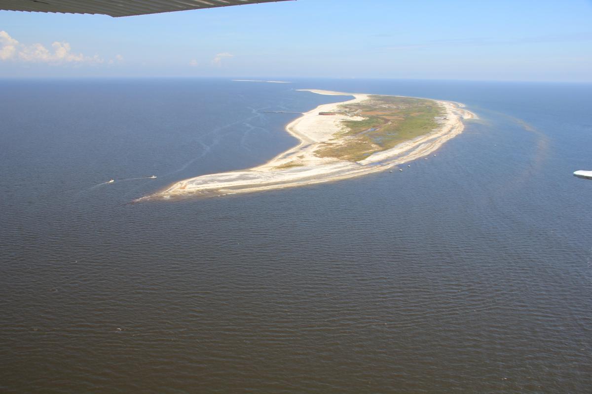 Oblique aerial photograph of West Ship Island, Mississippi, from 2012. The island is almost 2,000 feet at its widest point. The view is easterly, with the mainland toward the left (Morgan and Westphal, 2016).
