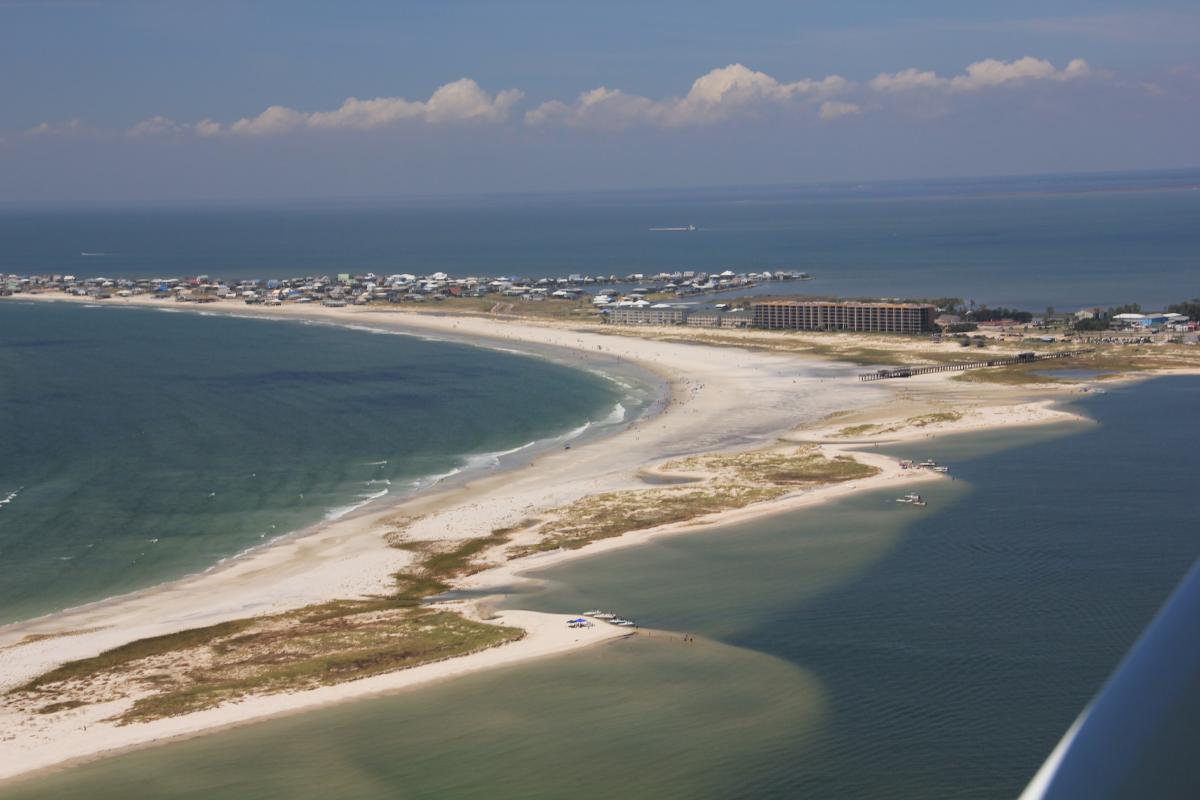 Oblique aerial photograph of Dauphin Island, Alabama, from 2012 (Morgan and Westphal, 2016). The view is toward the north-northwest, with Pelican Passage to the east; the mainland is visible in the distance.