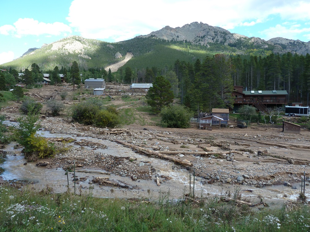 Photograph showing large debris flow scar (upper left quadrant of photograph) on the west side of Twin Sister Peak, near Rocky Mountain National Park, Colorado.  Debris flow and flood deposits appear in the foreground.
