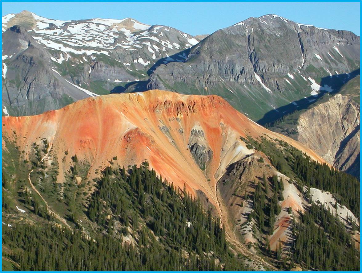 Acid neutralizing, regional propylitically altered igneous rocks (grayish-green), overprinted by younger acid-generating intensely altered rocks (red and yellow) in the Red Mountain mining district north of Silverton, Colorado.  Remote sensing datasets were used to map acid-generating and acid-neutralizing rocks that will aid in predicting water quality.  View to west.