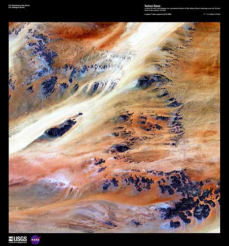 Dark outcroppings strung across the oranges and yellows of the Sahara Desert
