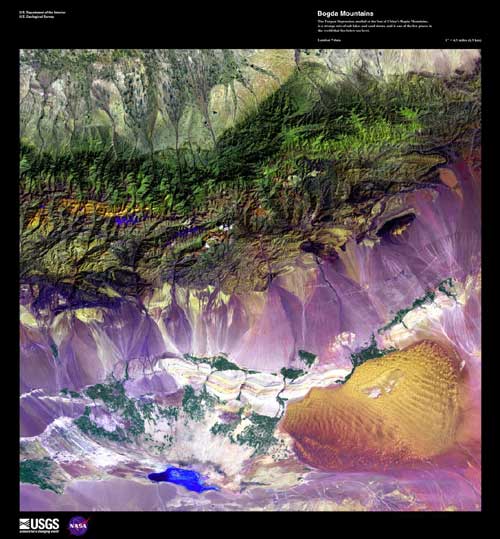 The Bogda Mountains next to the Turpan Depression. Green mountainous terrain at the top of the image. The bottom of the image is purple with a yellow spot on the right side. Groupings of green dots can be seen in the bottom of the image.