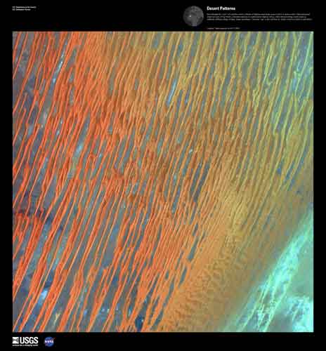 These sand dunes appear as sunset colored ribbons that stripe over Algeria